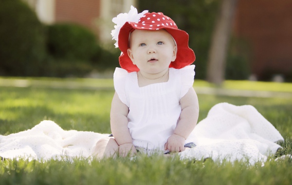 Маленькая девочка в белом платье и красной шляпе