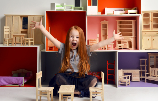 Маленькая девочка с игрушечной мебелью