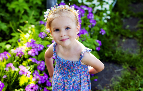 Маленькая улыбающаяся девочка с украшением в волосах 