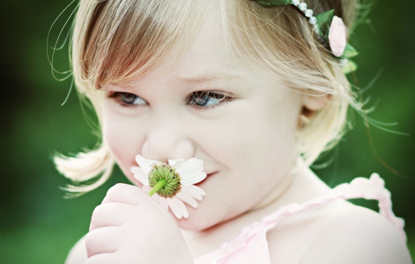 Милая девочка с красивыми глазами с ромашкой