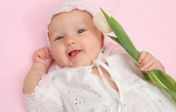 Улыбающийся младенец с тюльпаном