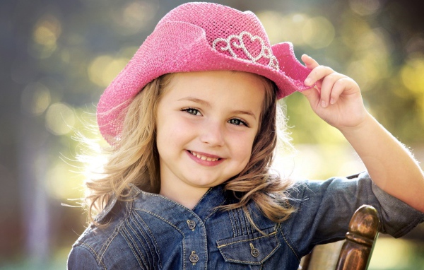 Улыбающаяся девочка в розовой шляпе