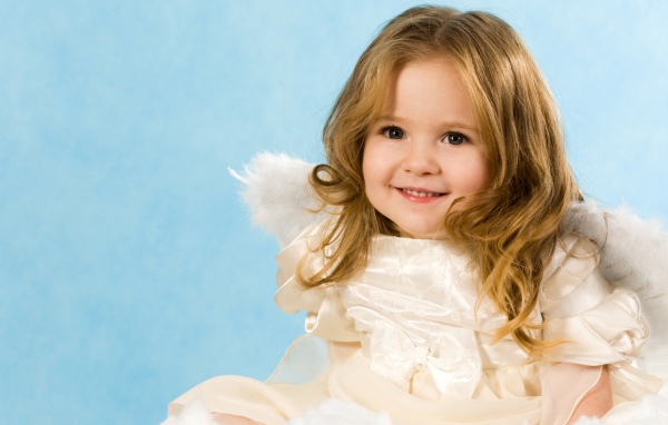 Улыбающаяся девочка с крыльями ангела