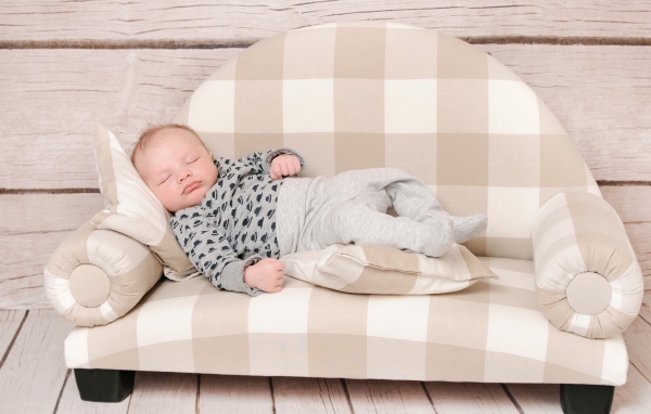 Грудной ребенок спит на диване