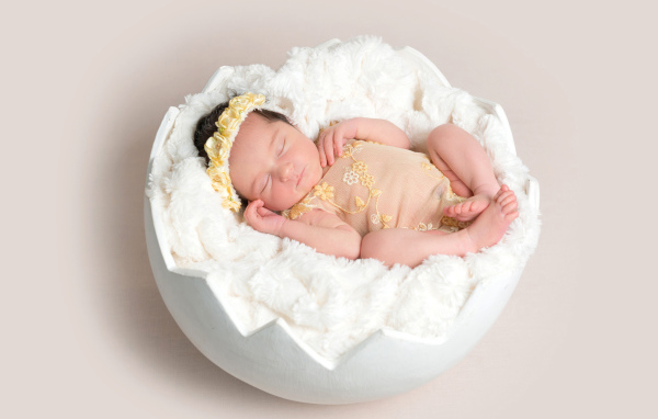 Младенец спит с мягкой белой скорлупе