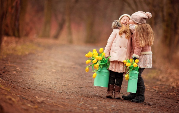Две маленькие девочки с желтыми тюльпанами весной