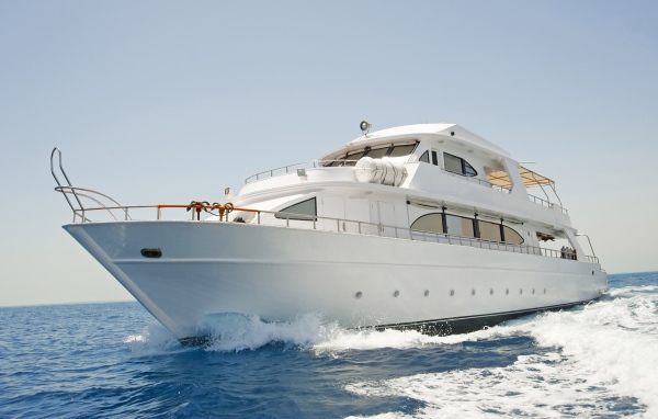 Красивая белая яхта в море на фоне голубого неба 