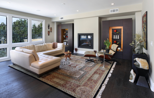 A stylish living room with a white leather sofa and carpet on the floor.