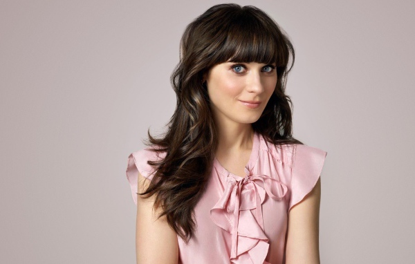 Актриса Зоуи Дешанель в розовом платье на сером фоне