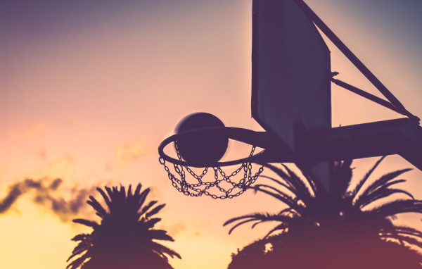 Баскетбольное кольцо с мячом на закате
