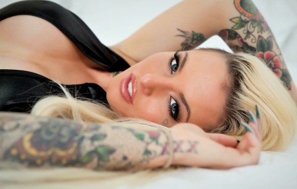 Beautiful blue-eyed blonde with arms in tattoos