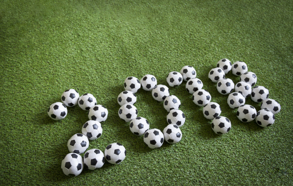 Цифры 2018 из футбольных мячей на зеленой траве