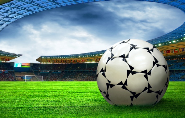 Футбольный мяч на зеленой траве стадиона