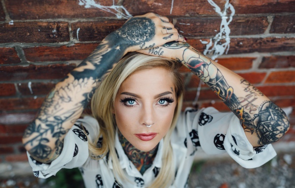 Молодая девушка блондинка с татуировками по телу
