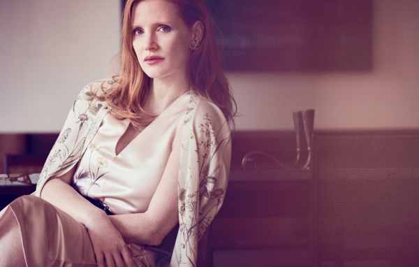 Молодая рыжеволосая актриса Джессика Честейн сидит на стуле