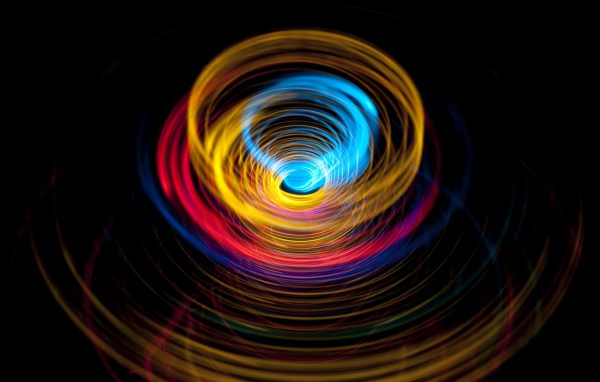 Разноцветные круги в воронке на черном фоне
