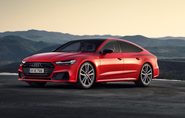Красный автомобиль Audi A7 Sportback 55 TFSI E Quattro S Line 2019 года в горах