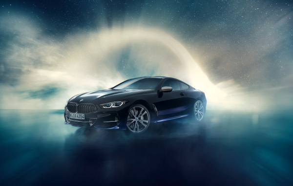 Черный автомобиль BMW M850i, 2019 года на фоне неба