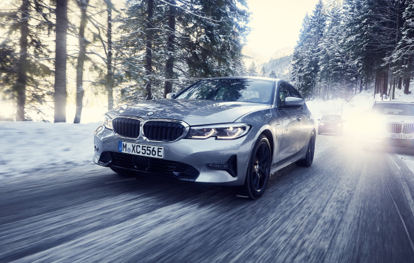 Серый автомобиль BMW 330e 2019 года на скользкой трассе