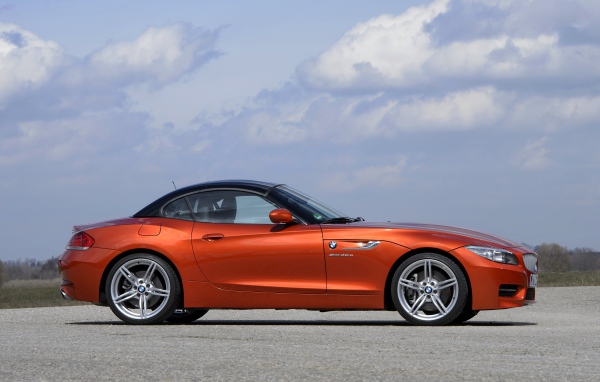 Оранжевый автомобиль BMW Z4 на фоне красивого неба