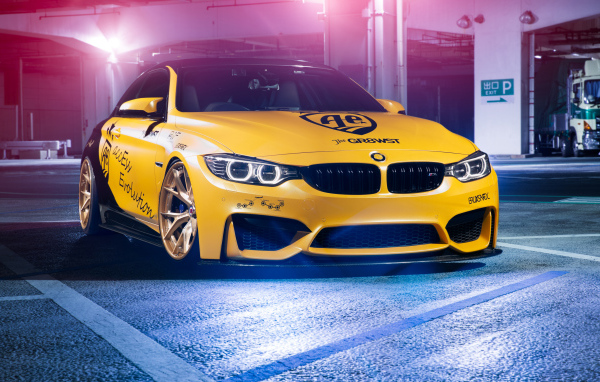 Желтый автомобиль BMW M4 в гараже 