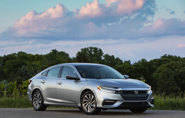 Серебристый автомобиль Honda Insight на фоне леса