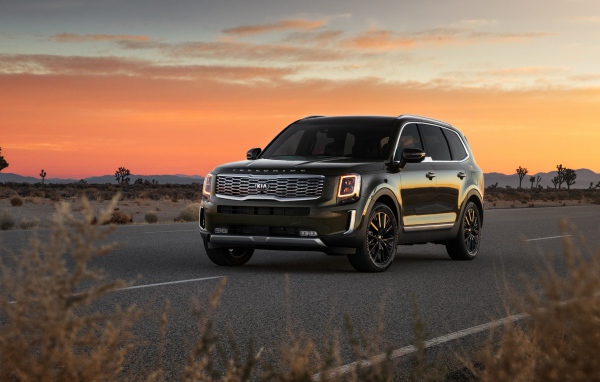 Черный внедорожник Kia Telluride, 2020 года на фоне заката 