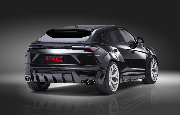 Черный Novitec Lamborghini Urus Esteso 2019 года вид сзади на сером фоне
