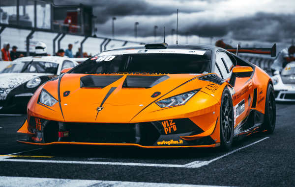 Оранжевый автомобиль Lamborghini Aventador на гонках