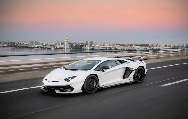Белый автомобиль Lamborghini Aventador на трассе