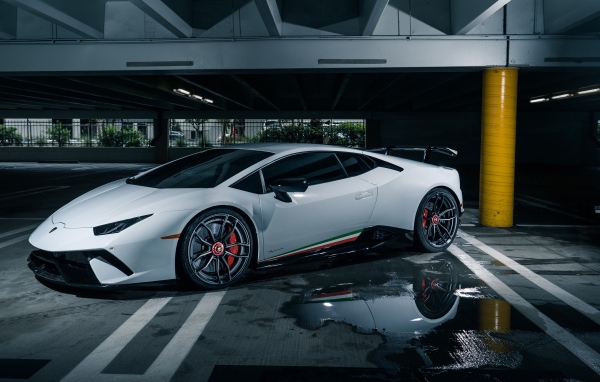 Белый спортивный автомобиль Lamborghini Aventador на подземной парковке