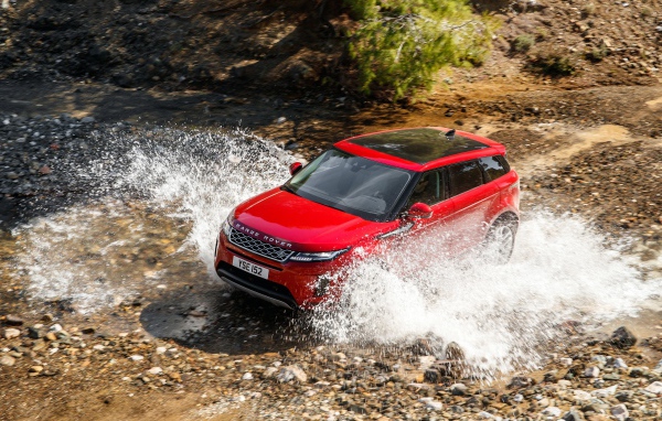 Красный внедорожник Range Rover Evoque D240 S 2019 года едет по воде