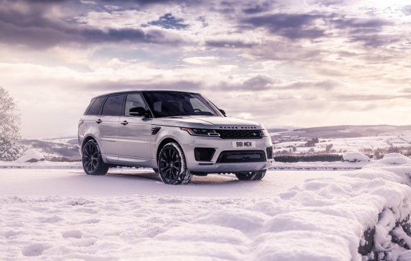Серебристый внедорожник Range Rover Sport стоит на снегу