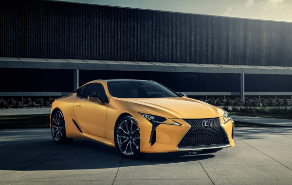 Желтый автомобиль Lexus LC 500 на фоне стены