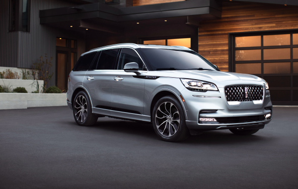 Серебристый внедорожник Lincoln Aviator Grand Touring, 2020 года на фоне дома