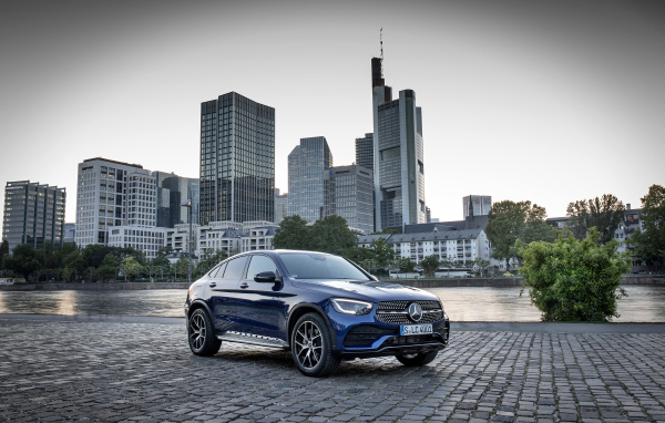 Синий автомобиль Mercedes-Benz GLC-Class на фоне небоскребов