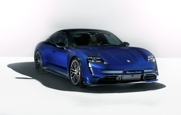 Синий автомобиль Porsche Taycan Turbo 2019 года на сером фоне