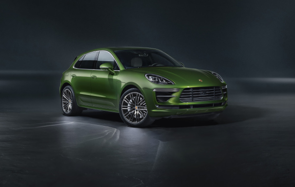 Зеленый автомобиль Porsche Macan Turbo 2019 года на сером фоне