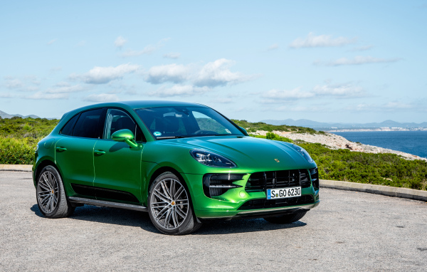 Зеленый внедорожник Porsche Macan S,  2018 года на фоне горизонта 