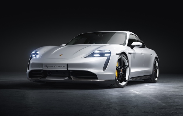 Серебристый автомобиль Porsche Taycan Turbo S 2019 года на сером фоне