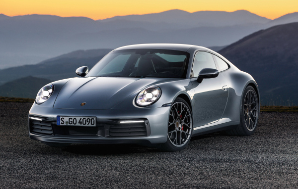 Серебристый автомобиль Porsche 911 Carrera 4S 2019 года на фоне гор 
