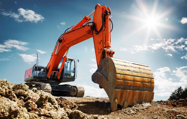 Excavator with bucket against a blue sky