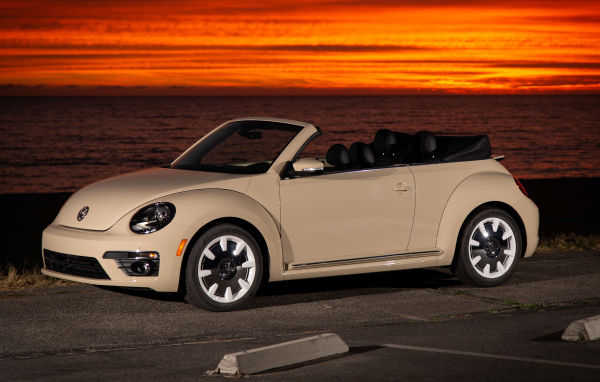 Белый кабриолет Volkswagen Beetle SEL на фоне океана на закате