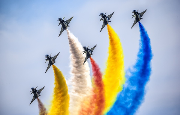 Fighters with colorful smoke in the sky