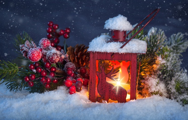 Рождественский фонарь на снегу с еловой веткой