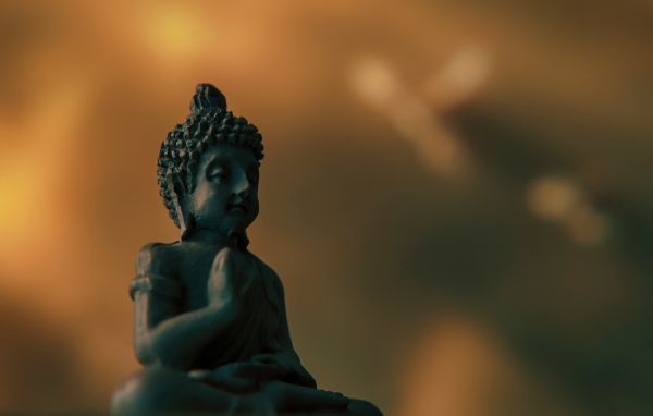 Buddha figurine on a brown background close-up