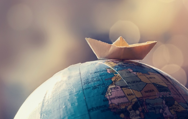 Бумажный кораблик лежит на глобусе