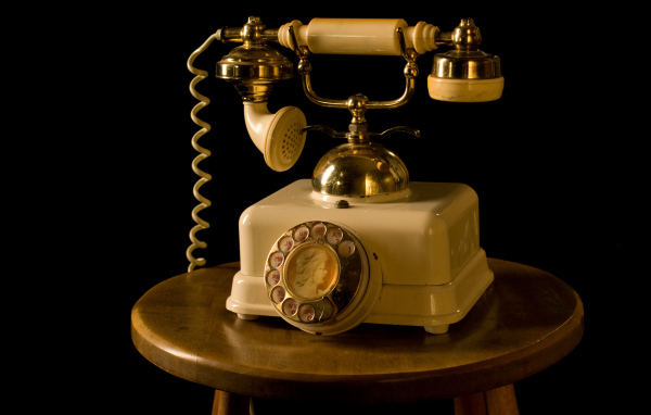 Ретро телефон на тумбочке на черном фоне