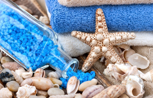 Морская звезда, бутылка с морской солью, ракушки и полотенца