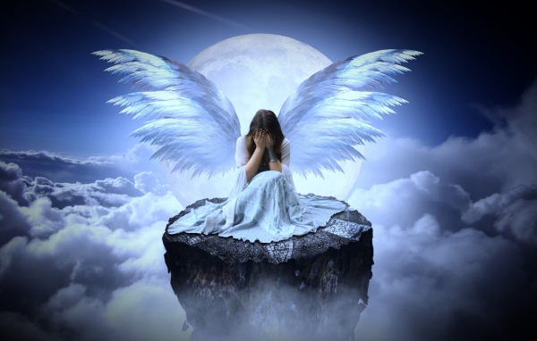 Девушка с крыльями ангела сидит на камне в облаках